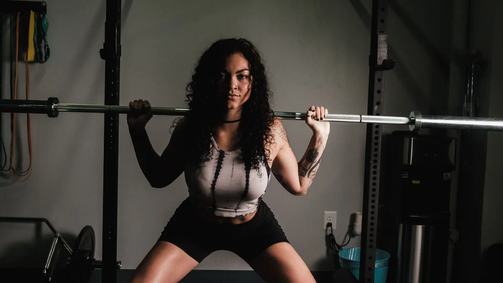 Woman performing a barbell back squat in a gym