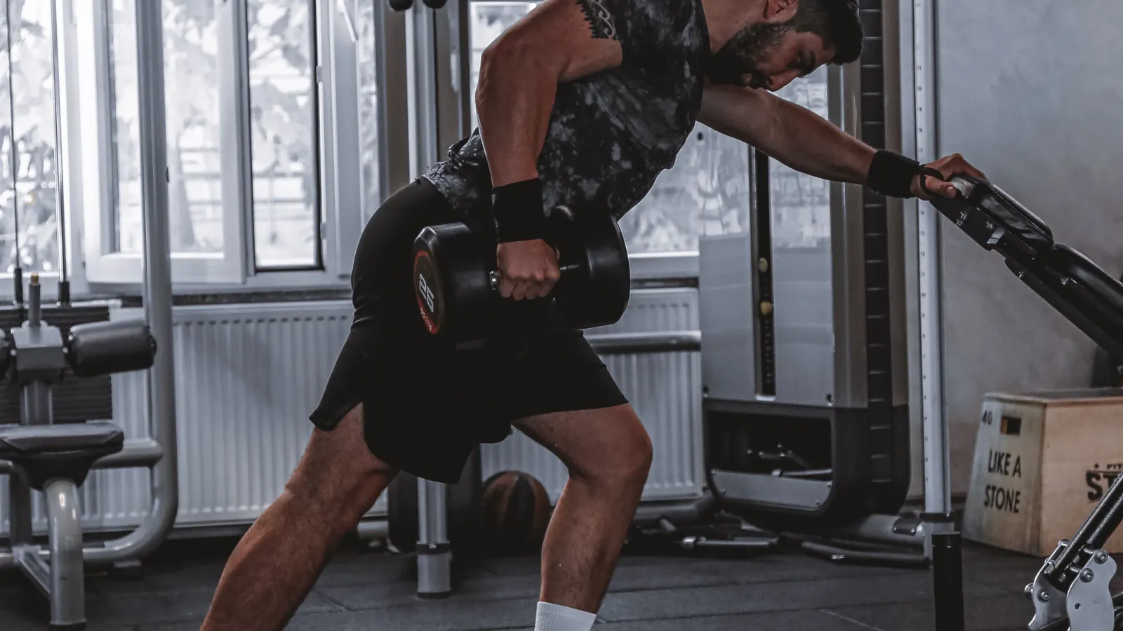 Man performing a single-arm dumbbell row in a gym